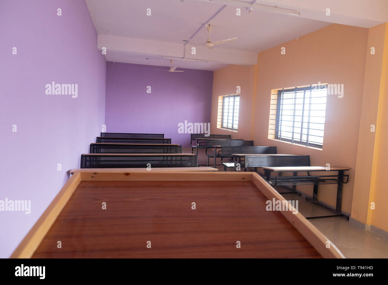 Classe vuota camera e scrivanie con pareti colorate Foto Stock
