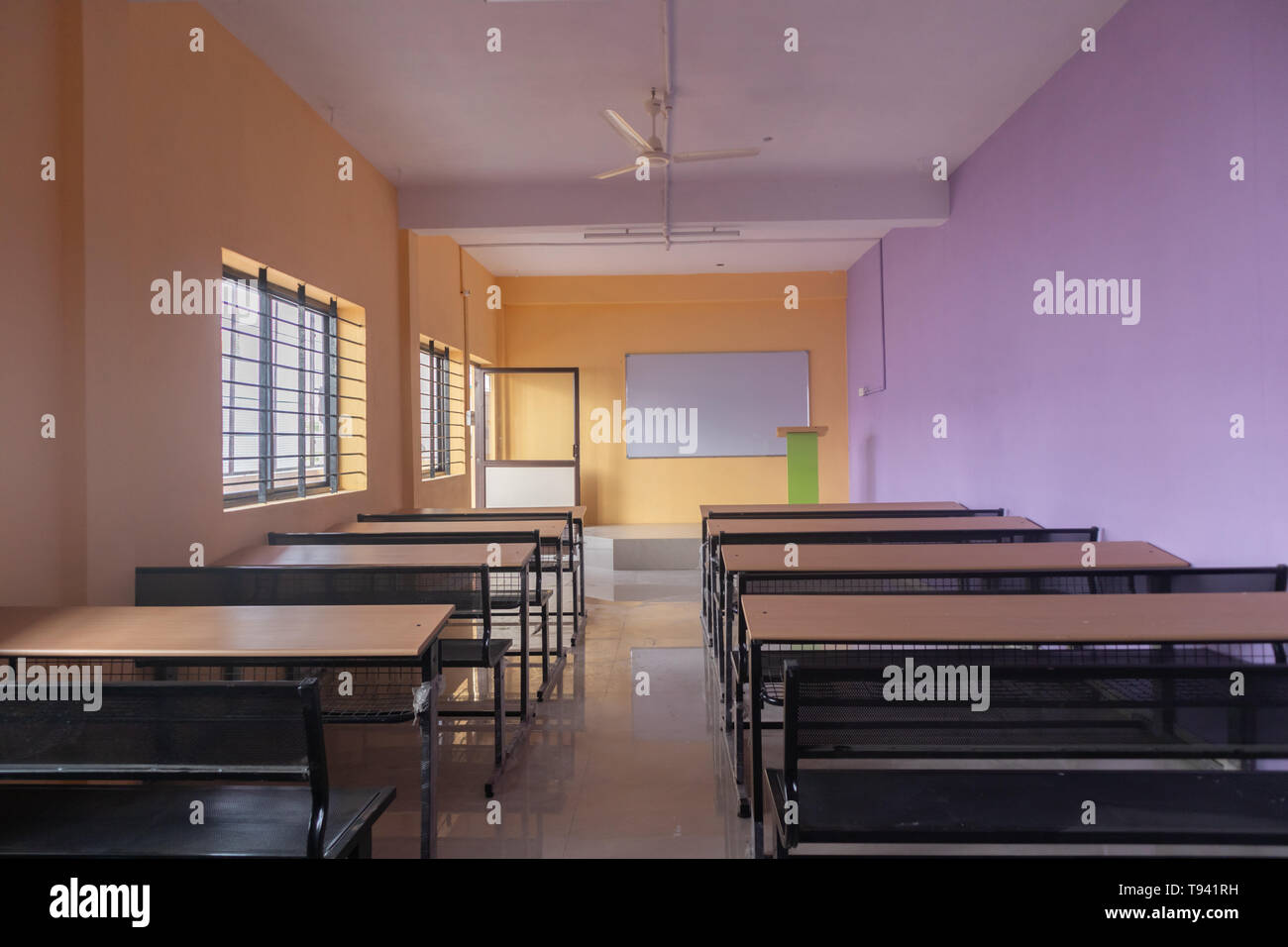 Classe vuota camera e scrivanie con pareti colorate Foto Stock
