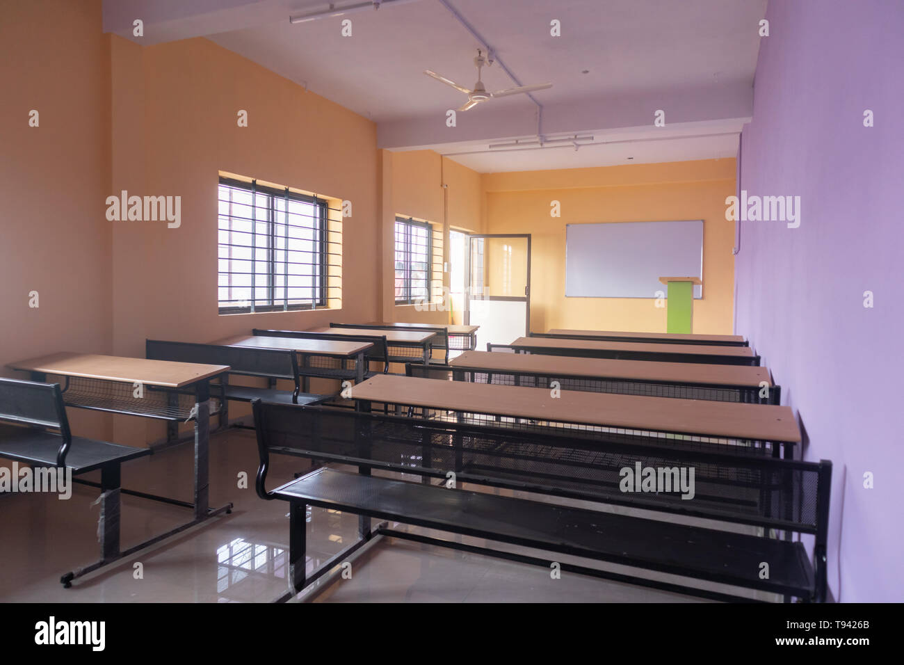 Classe vuota camera e scrivanie con pareti colorate Foto Stock