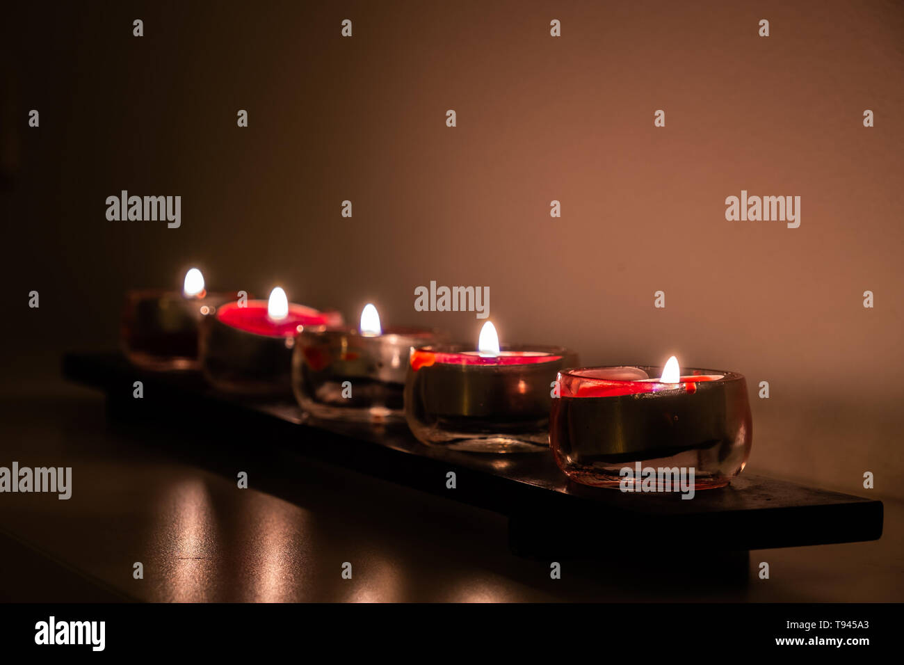 Un rotolo di piccole candele rosse come sorgente di luce. Foto Stock