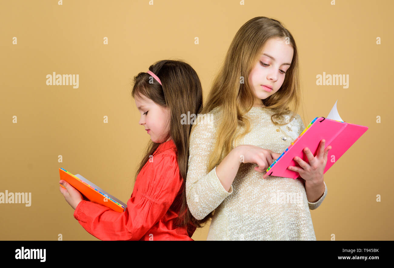 Amicizia e fraternità. Gli studenti la lettura di un libro. Progetto Scuola. Le cartelle di lavoro per la scrittura. Si torna a scuola. le piccole bambine con nota libri. piccolo felice bambini pronti per la lezione. Ispirato a lavorare sodo. Foto Stock