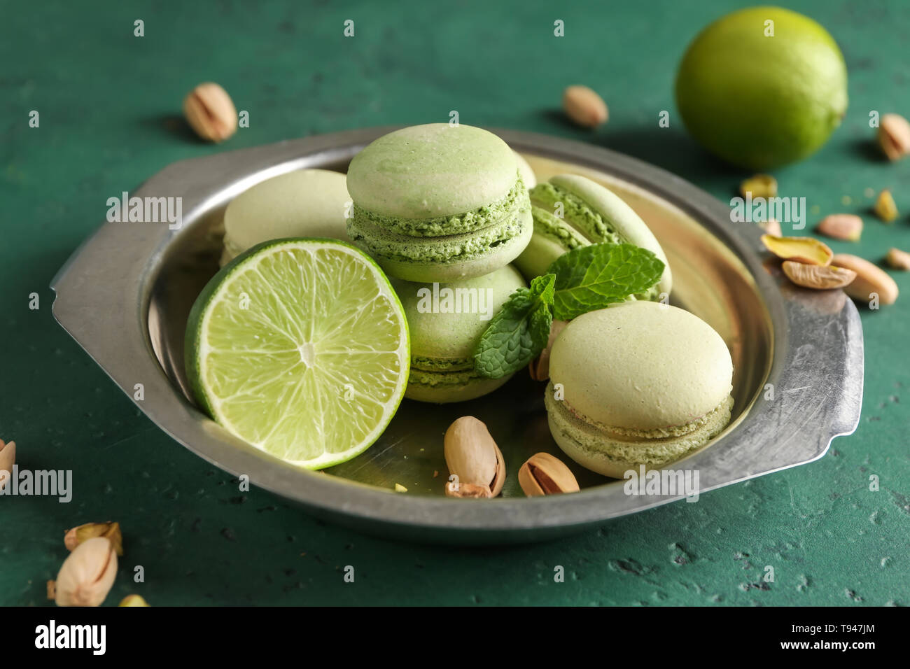 Piastra con gustosi amaretti, i pistacchi, menta e calce sulla tabella dei colori Foto Stock