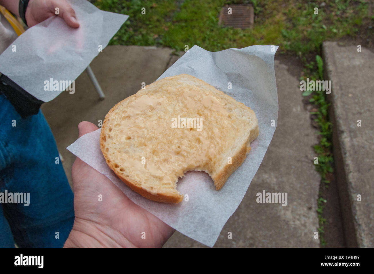 La condivisione di un pezzo di freschi fatti in casa pane bianco spalmato di burro di acero in Chateau più ricco di Québec Canada Foto Stock