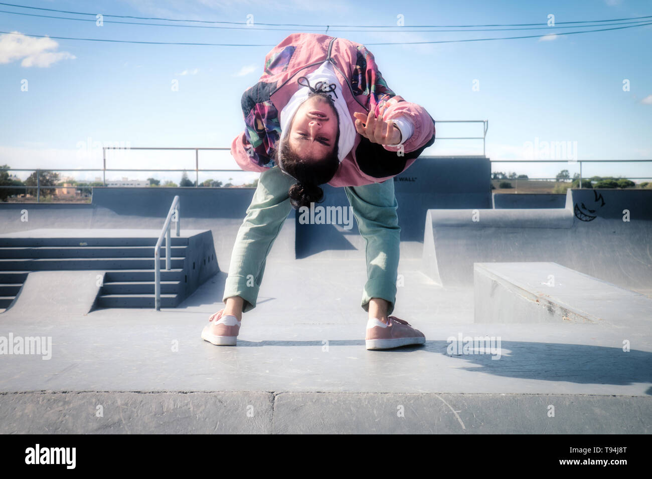 Giovane ballerina bianca danza hip-hop freestyle in uno skate park Foto Stock