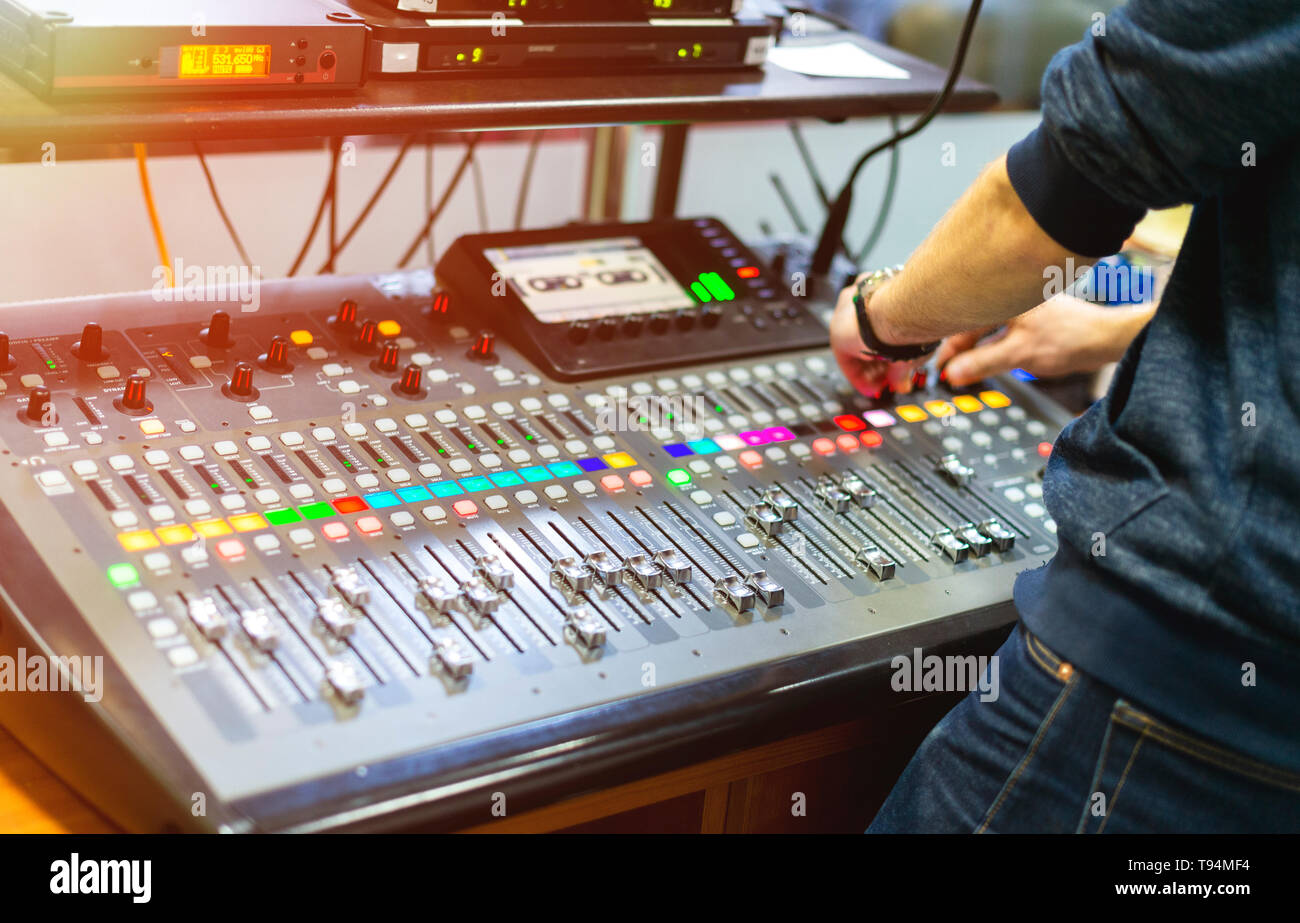 Uomo con console di mixaggio audio in studio di registrazione Foto Stock