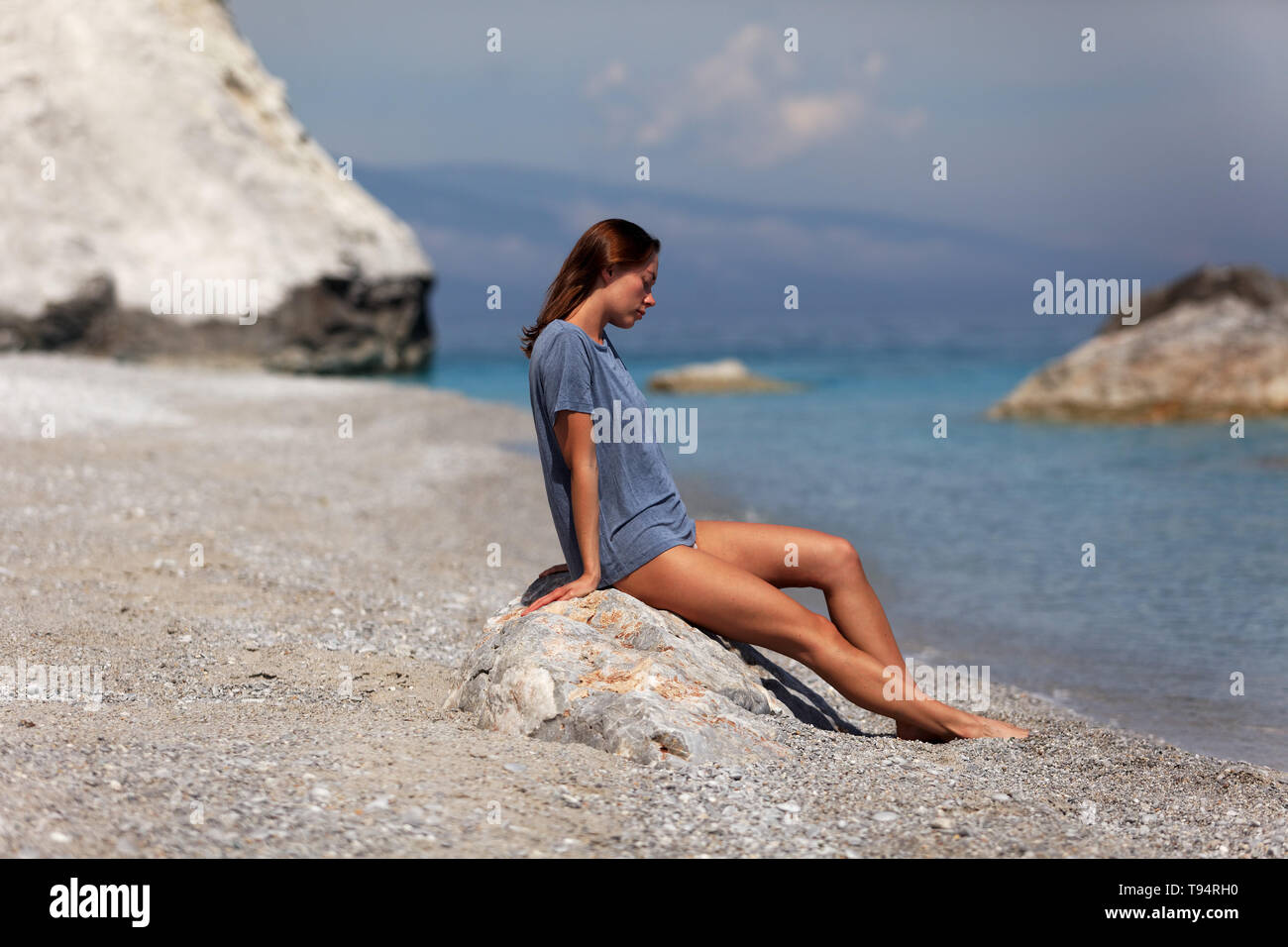 Giovane donna rilassante sulla spiaggia Foto Stock