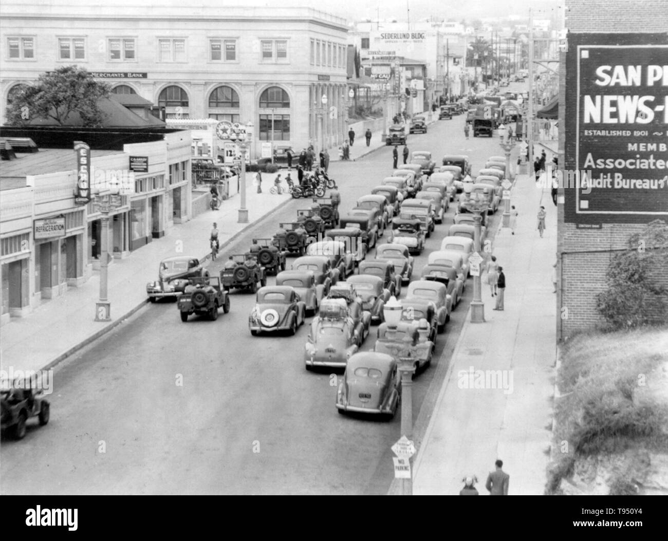 Titolo: "carovana di vetture, con molti scorta militare veicoli, W. settimo san & S. Pacific Avenue." L'internamento di Japanese-Americans durante la seconda guerra mondiale è stato il trasferimento forzato e la detenzione nei campi di 110,000-120,000 persone di ascendenza giapponese (62% degli internati erano cittadini statunitensi) ordinato dal presidente Roosevelt poco dopo il Giappone di attacco a Pearl Harbor. Japanese-Americans sono stati incarcerati basato sulla popolazione locale di concentrazioni e politica regionale. Foto Stock