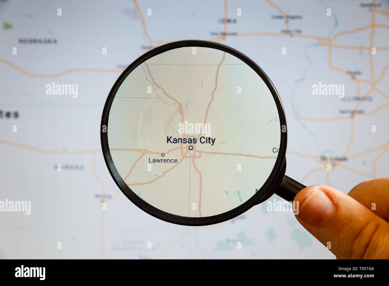 Kansas City, Stati Uniti. Mappa politico. La città sullo schermo del monitor attraverso una lente di ingrandimento in mano. Foto Stock