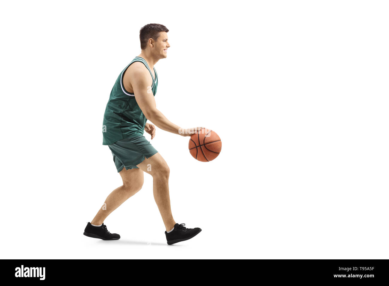 Lunghezza piena ripresa di profilo di un ragazzo di giocare a basket e conduce una sfera isolata su sfondo bianco Foto Stock