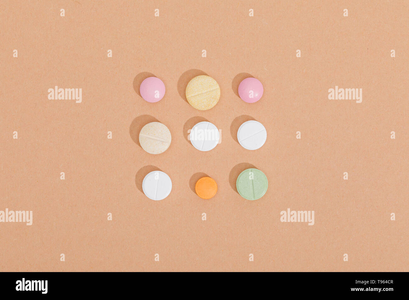 Piatto con laici pillole colorate sulla superficie marrone Foto Stock