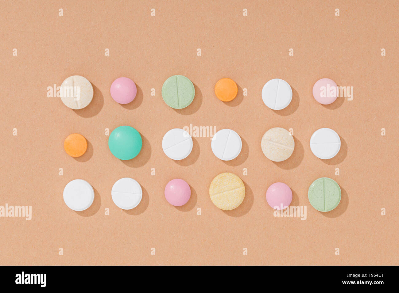 Piatto con laici pillole colorate sulla superficie marrone Foto Stock