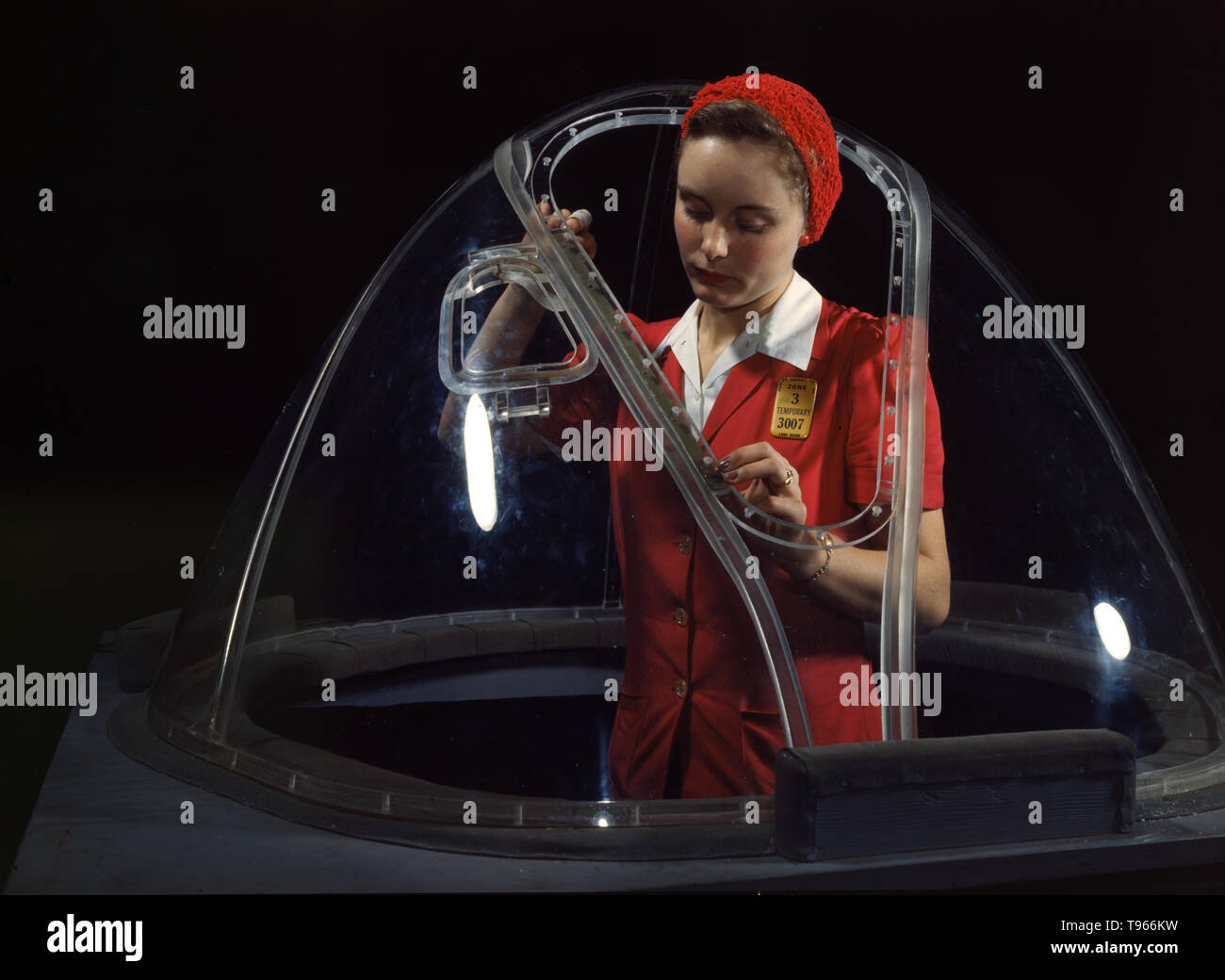 Phyllis Ann Marxson Clark, un anno 18 Old North Dakota native, in una casa di vetro è messa tocchi di rifinitura sul Bombardier sezione anteriore di un B-17F navy bombardiere, Long Beach, California Lei è uno dei tanti in grado di lavoratori di sesso femminile in la Douglas Aircraft Company impianto. Sebbene l'immagine di 'Rosie la rivettatrice' riflette il lavoro industriale di saldatrici e rivettatrici, la maggior parte delle donne che lavorano riempito non-factory posizioni in ogni settore dell'economia. . Fotografato da Alfred T. Palmer, 1942. Foto Stock