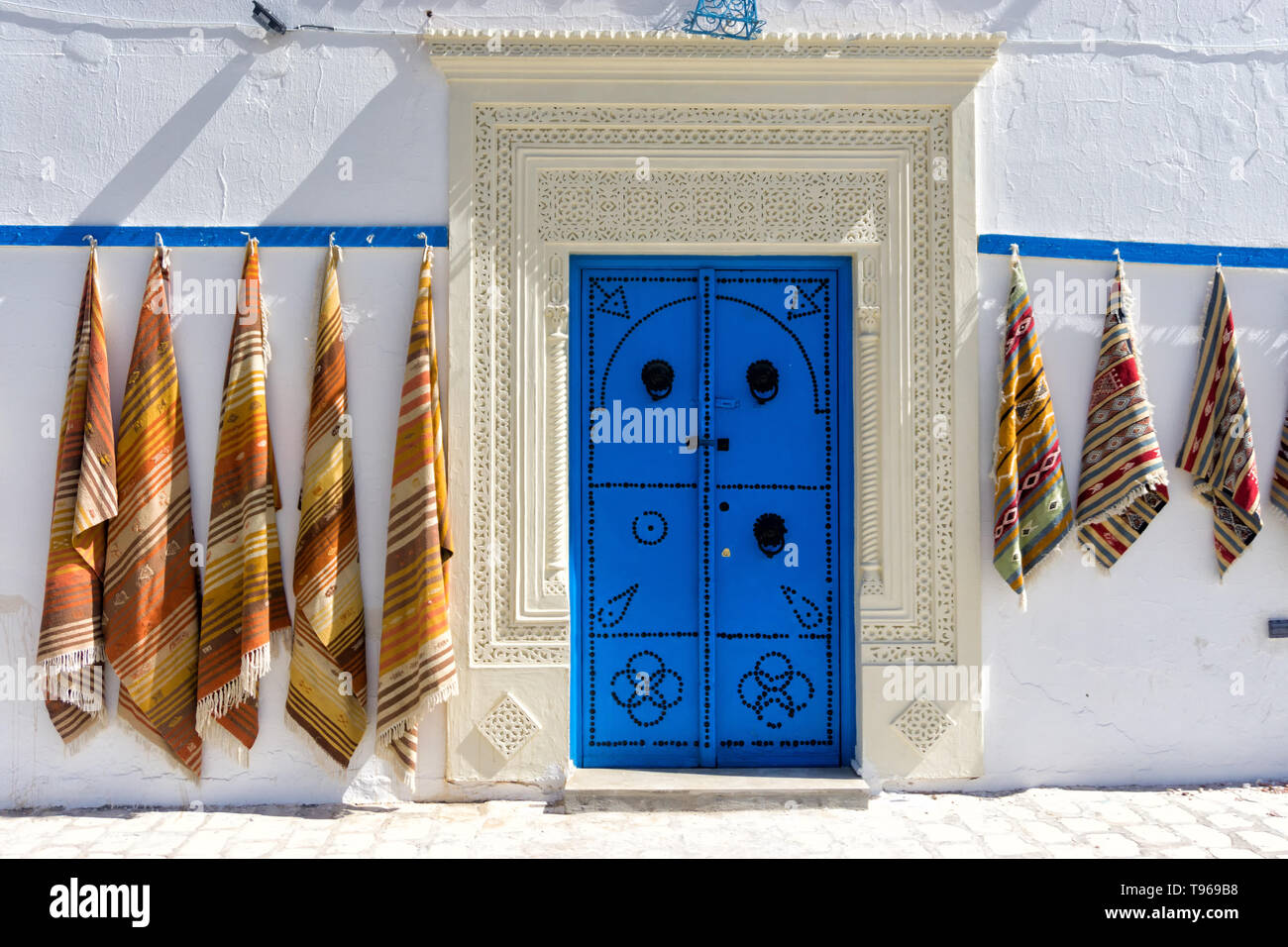 Ingresso con porta colorati e i tappeti in vendita in Kairouan, Tunisia. Foto Stock