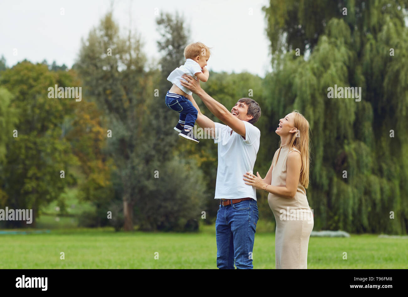 La famiglia felice che giocano nel parco. Foto Stock