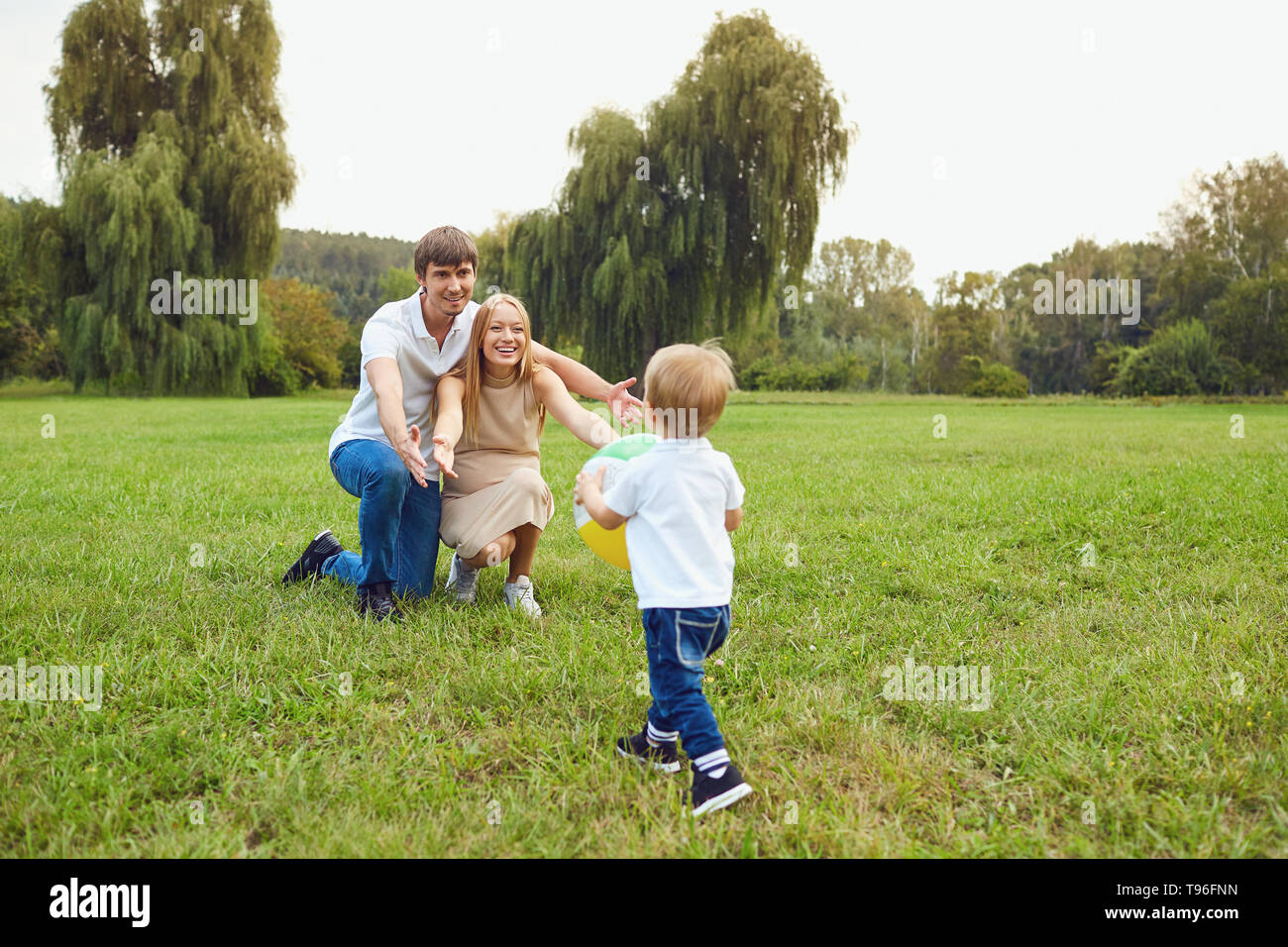 La famiglia felice giocando sull'erba nel parco. Foto Stock