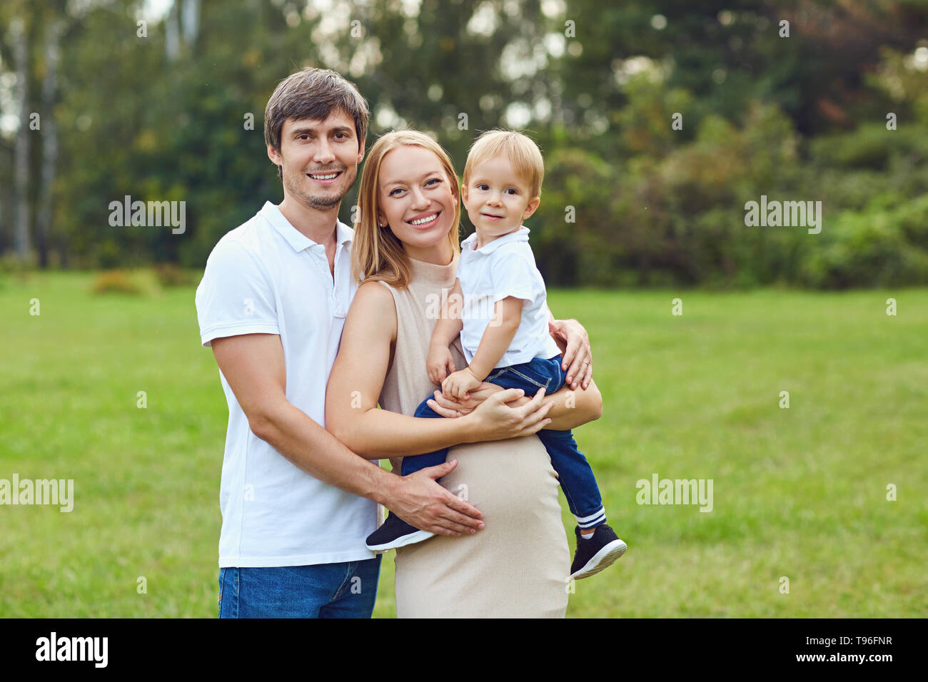 La famiglia felice insieme nel parco d'estate. Foto Stock