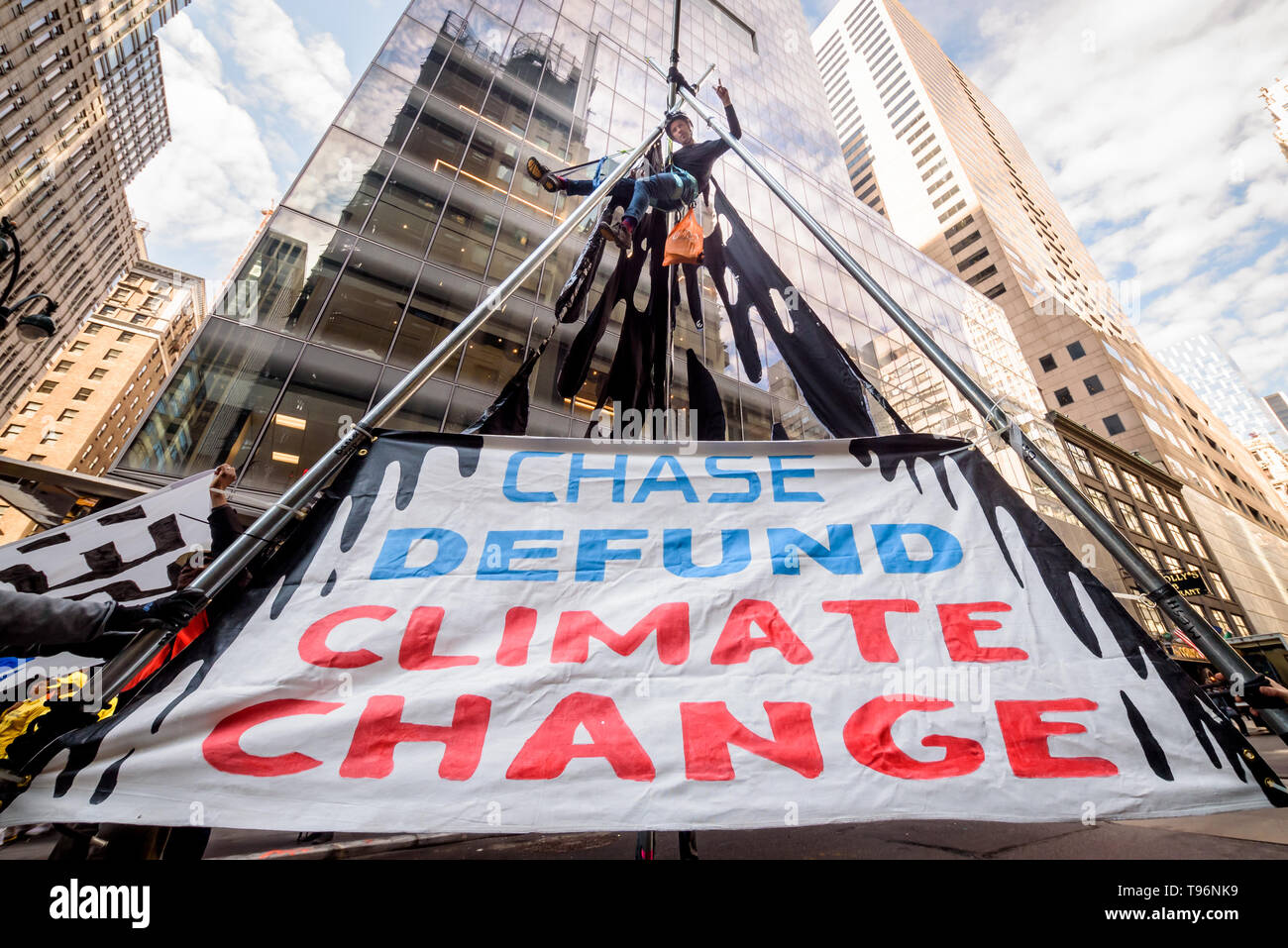 New York, Stati Uniti. 16 Maggio, 2019. Proteste contro la Chase Bank per il suo ruolo come il mondo peggiore finanziatore del cambiamento climatico escalation come attivisti del clima eretto e scalato a due piani, treppiede in acciaio struttura, bloccando 47th St at Madison Ave, nella parte anteriore del Chase è di nuovo flagship global corporate headquarters. Un arresto è stato mentre un gruppo di supporto di manifestanti hanno cantato e visualizzati banner chiamando il Chase per terminare il suo massiccio finanziamento dei combustibili fossili. Credito: Erik McGregor/Pacific Press/Alamy Live News Foto Stock