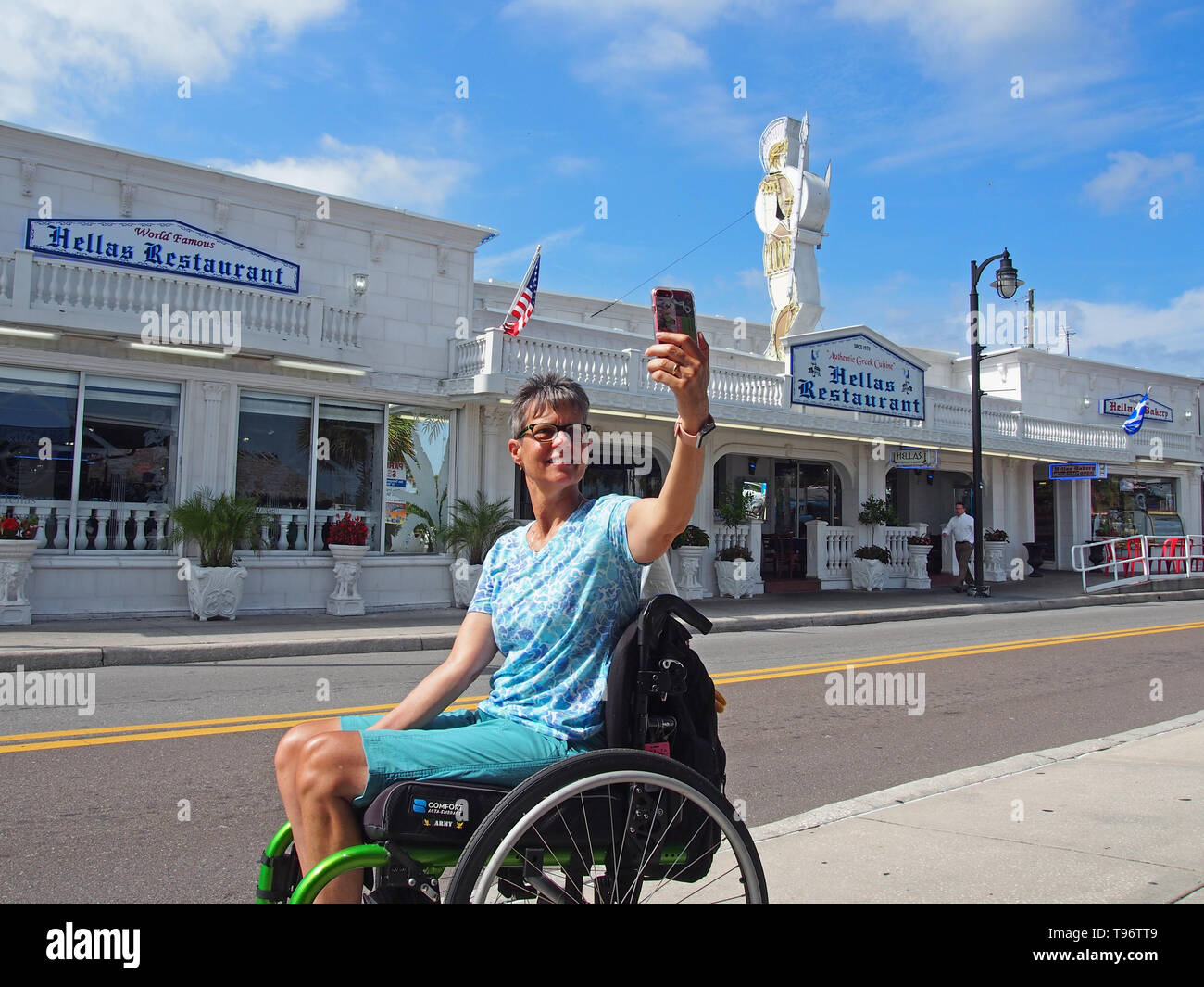 Donna disabile turistica prendendo selfie in Tarpon Springs, in Florida, Stati Uniti d'America, 9 maggio 2019, © Katharine Andriotis Foto Stock