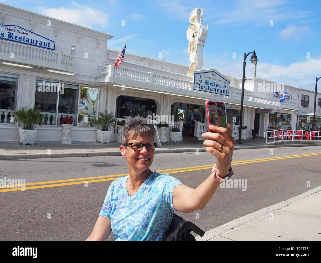 Donna disabile turistica prendendo selfie in Tarpon Springs, in Florida, Stati Uniti d'America, 9 maggio 2019, © Katharine Andriotis Foto Stock