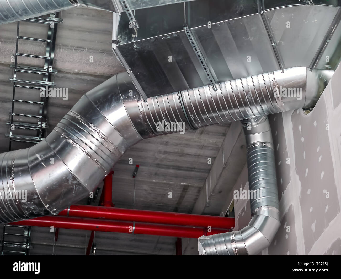 Nuova installazione di acciaio aria condizionata tubi del condotto nell'edificio industriale Foto Stock