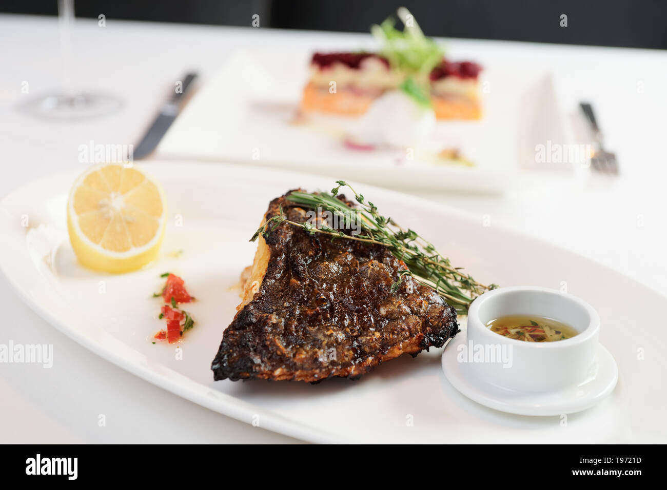 La Passera di mare alla griglia con limone e salsa saporita sul ristorante tabella Foto Stock