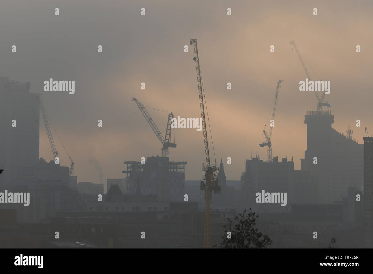 Una silhouette atmosferica di Leeds skyline in fase di sviluppo in una nebbiosa alba Foto Stock