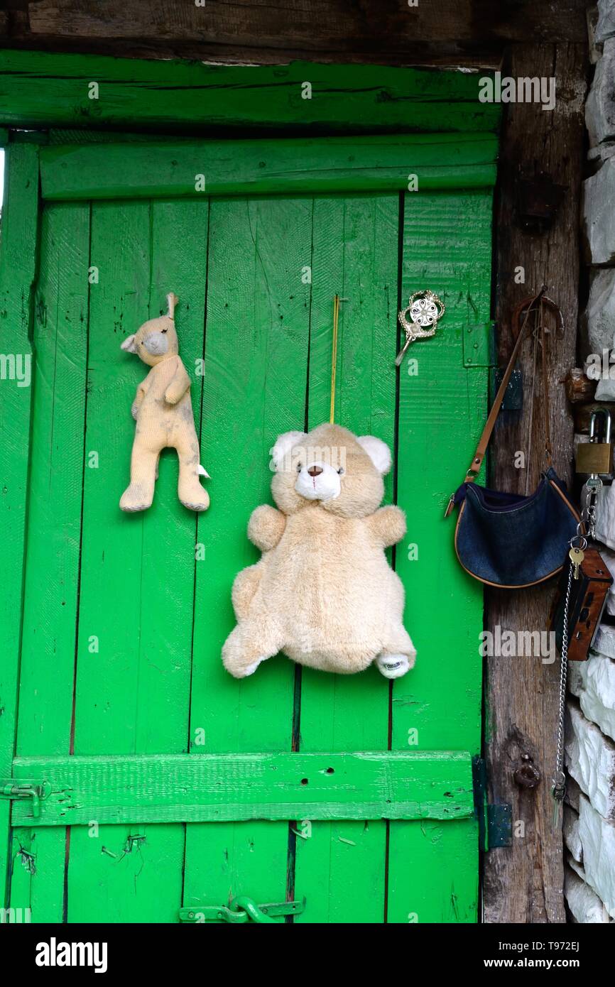 Giocattoli appeso su una porta di un rurale villaggio albanese per scongiurare distrarre malocchio o gelosia Albania Foto Stock