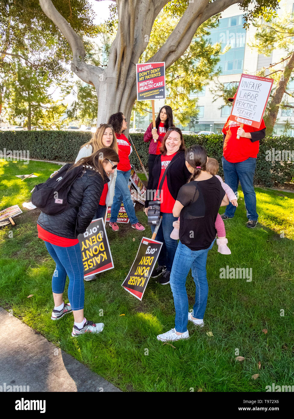 Gli operatori dei centri di salute mentale picket una organizzazione per la tutela della salute a Irvine, CA, a chiedere fondi per più frequenti della cura del paziente. Foto Stock