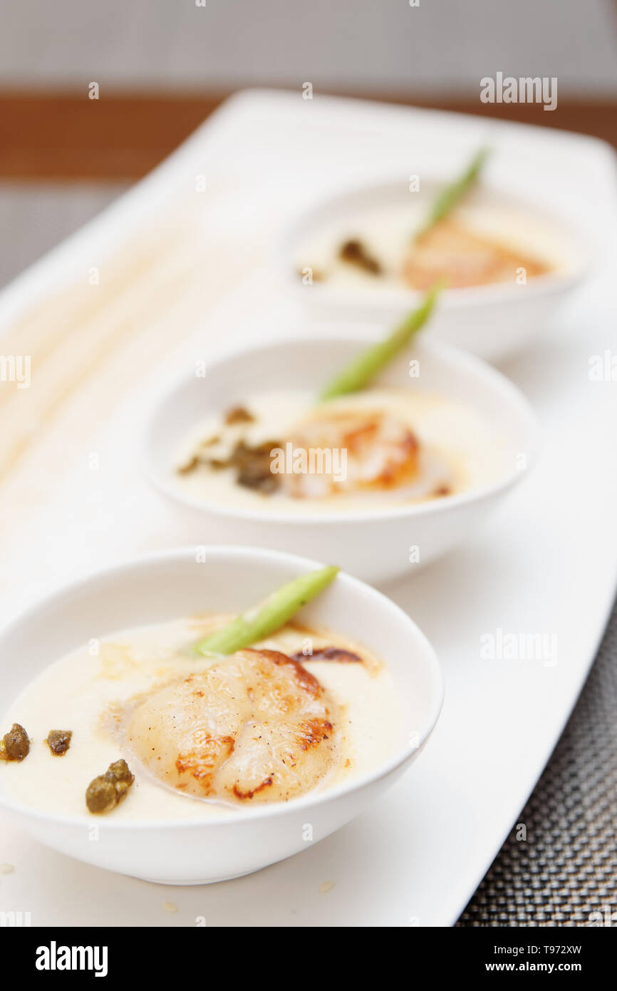 Grigliata di capesante di mare con una spessa salsa cremosa Foto Stock