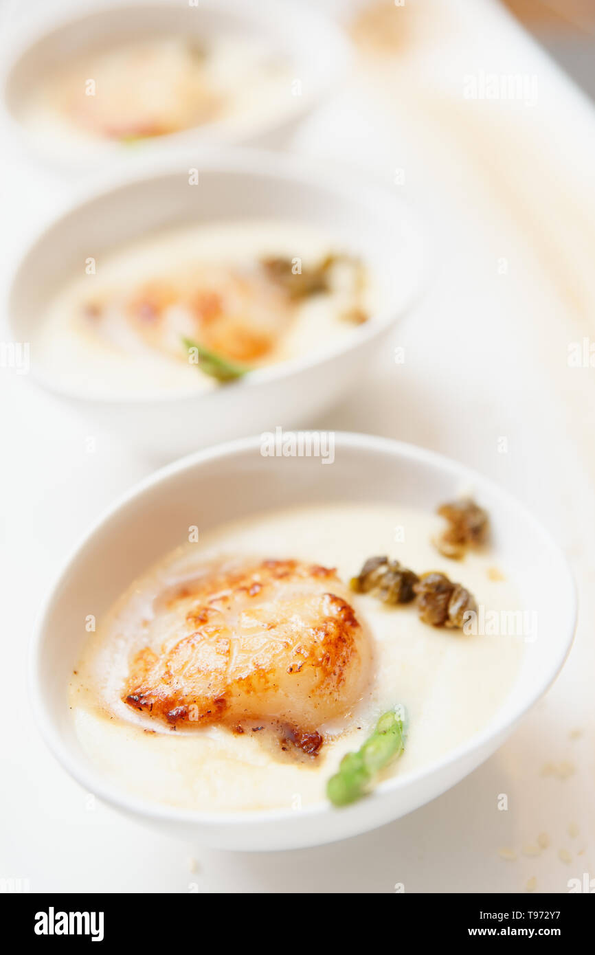 Grigliata di capesante di mare con una spessa salsa cremosa, close-up Foto Stock