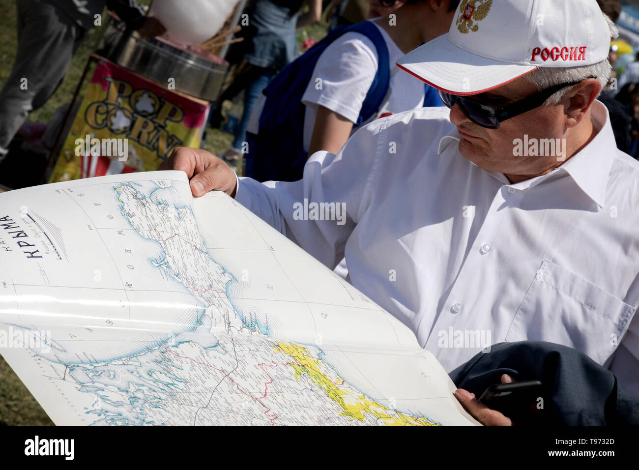 Un uomo esamina una mappa della penisola della Crimea su una vacanza nella città di Bakhchisarai, Repubblica di Crimea Foto Stock