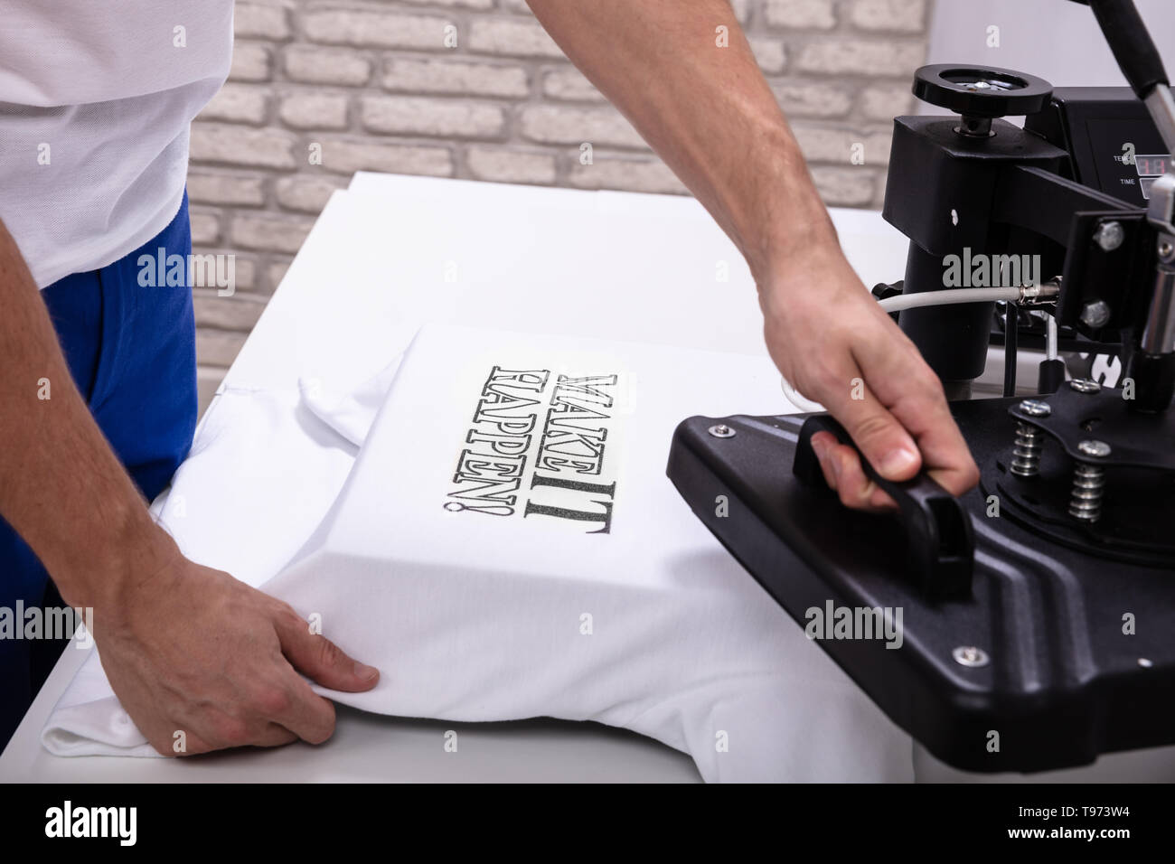 L'uomo stampa su t shirt in officina Foto Stock