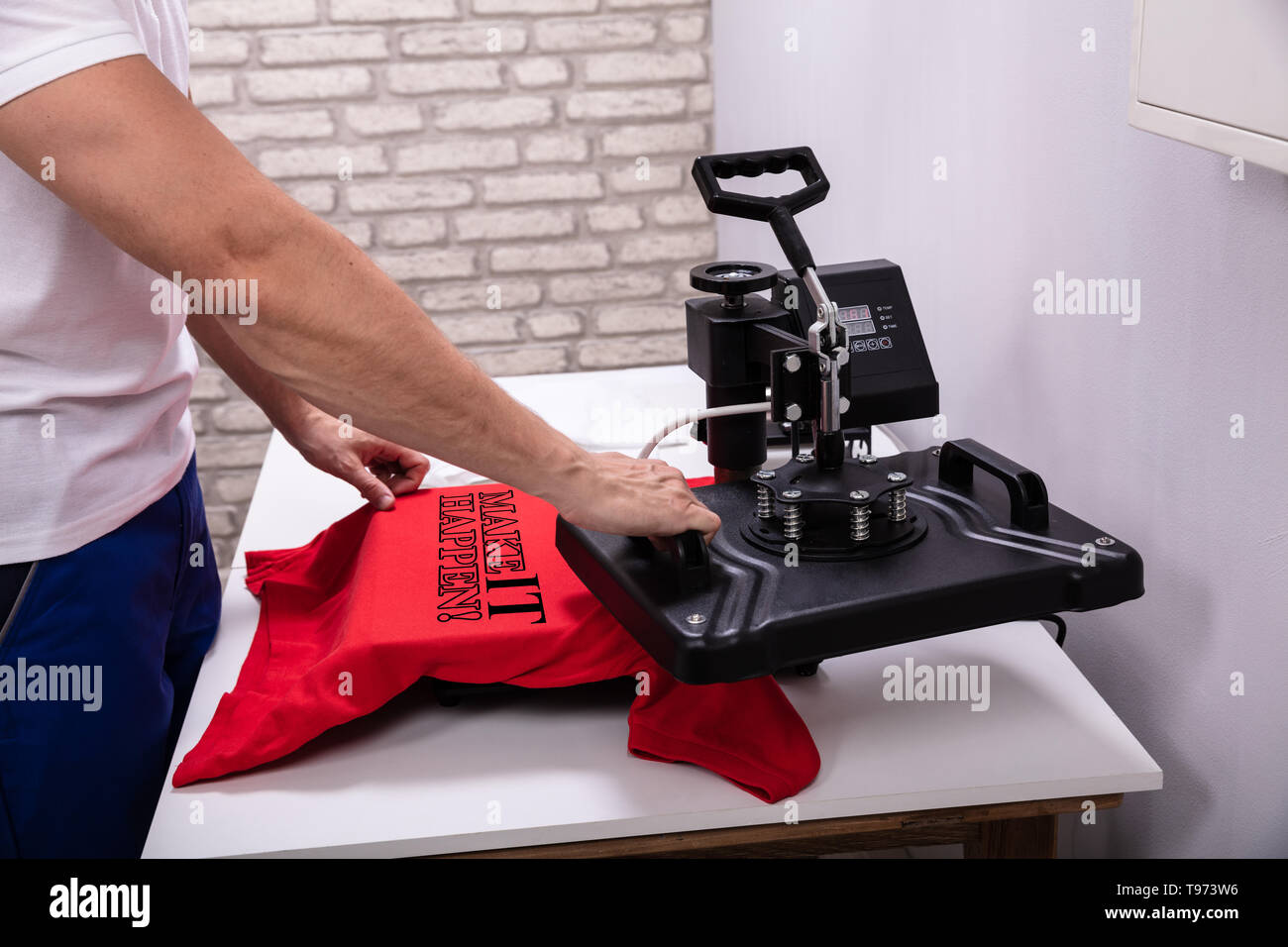 L'uomo stampa su t shirt in officina Foto Stock