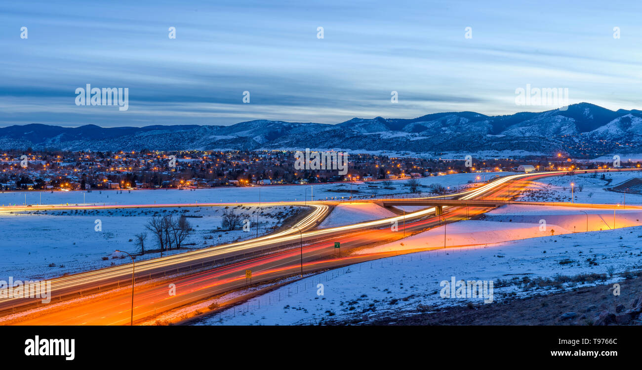Inverno Highway - Una vista panoramica della U.S. Autostrada 285 avvolgimento a foothill del Front Range delle Montagne Rocciose su un burrascoso sera d'inverno. Denver, CO. Foto Stock