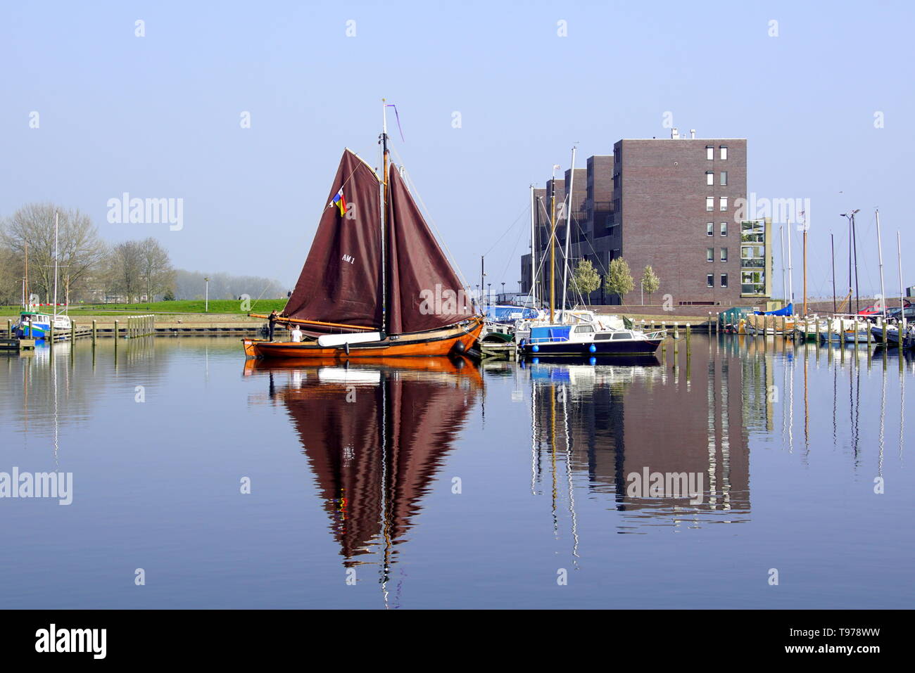 Almere, Paesi Bassi - 29 Marzo 2019: Barca e costruzione di riflettere nell'acqua del porto di Almere Haven. Foto Stock