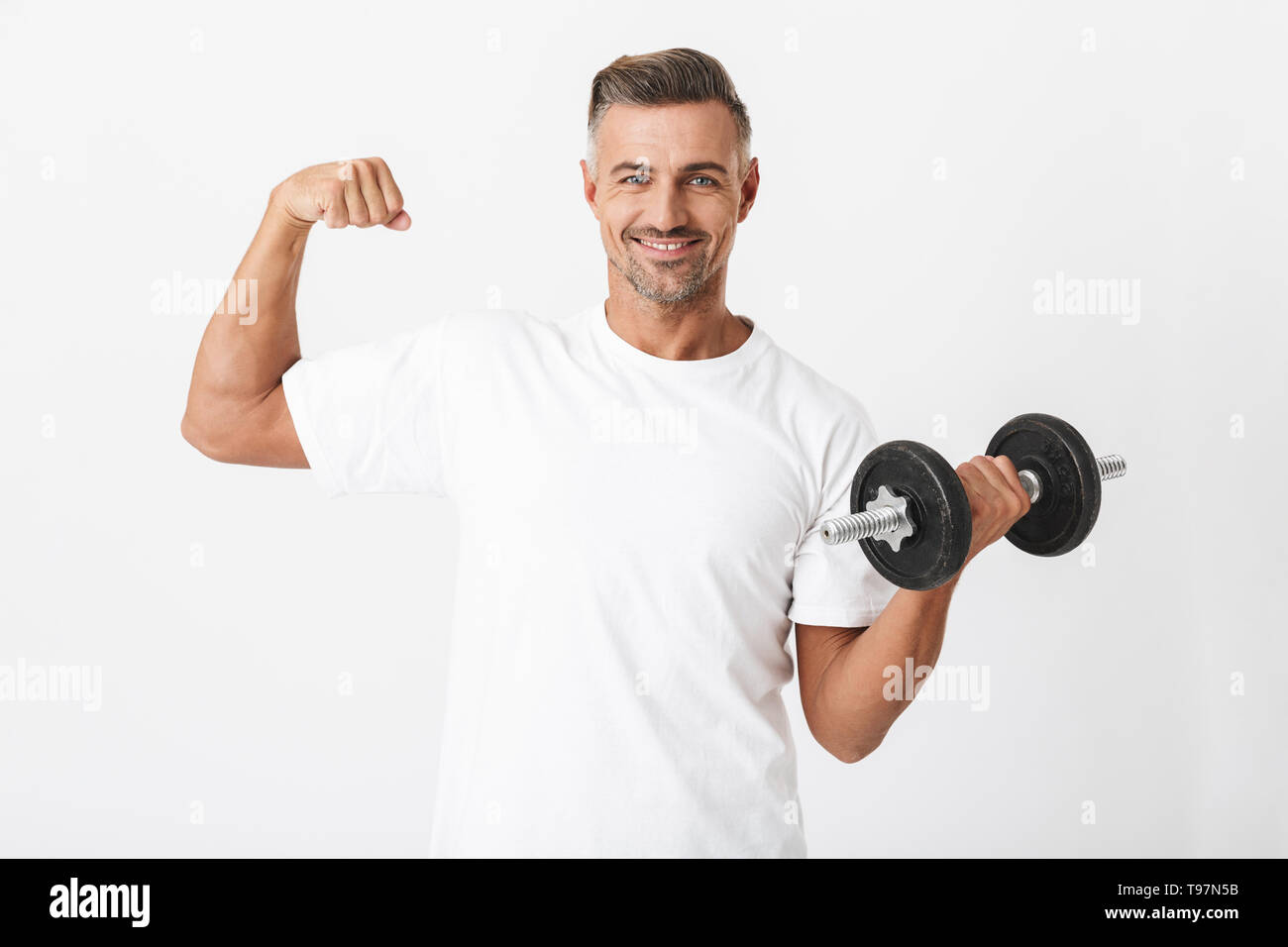 Immagine del culturista uomo 30s con usura delle setole t-shirt casual lacerti di pompaggio e sollevamento di pesi isolate su sfondo bianco Foto Stock