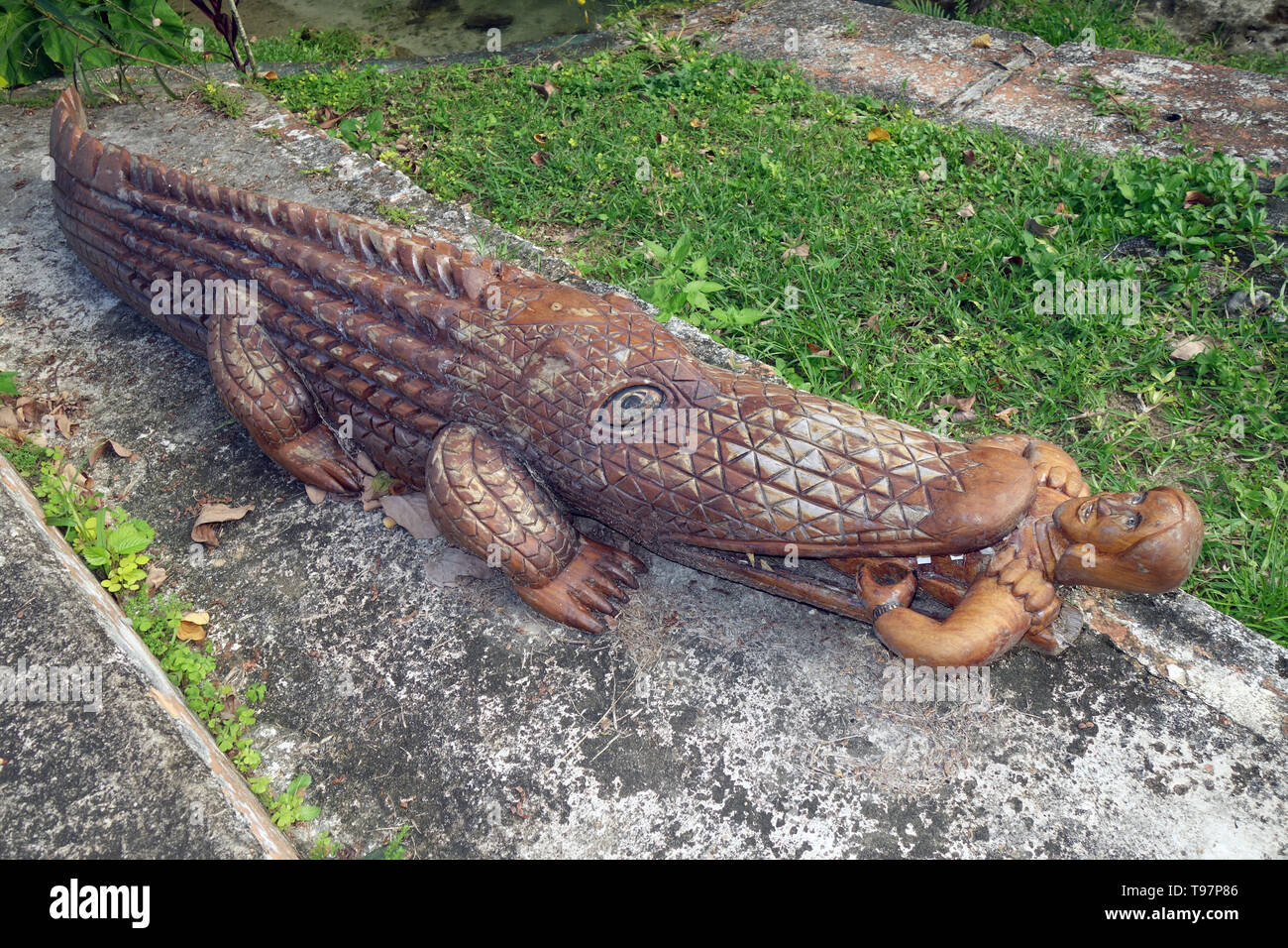 Scultura in legno del coccodrillo di mangiare una persona, mele Cascades, vicino a Port Vila, Efate, Vanuatu. N. PR Foto Stock