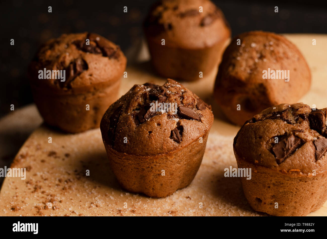 Tortini di cioccolato con scaglie di cioccolato su uno sfondo scuro. Fatte a mano. Foto Stock