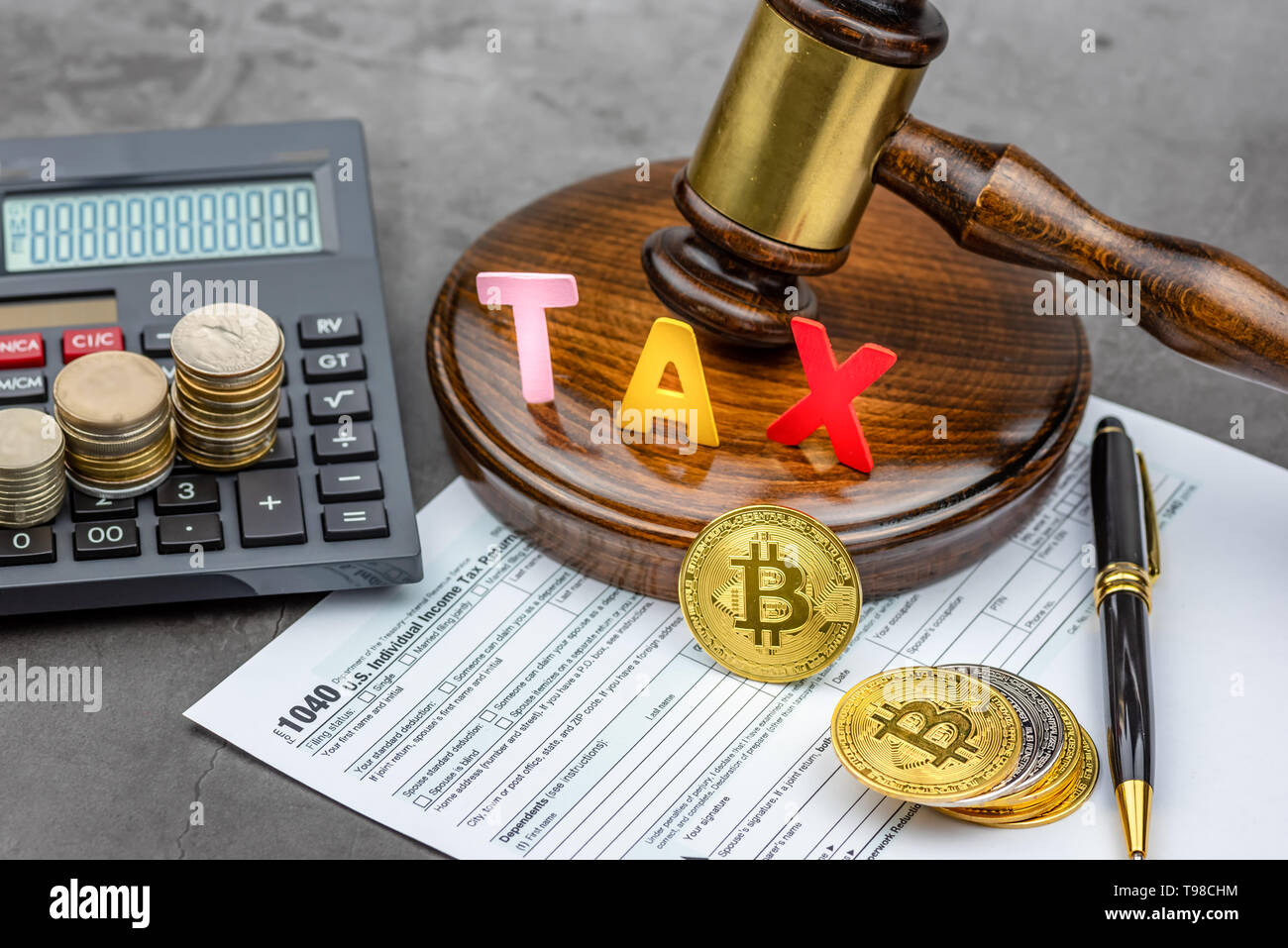 Vista frontale di Bitcoin cryptocurrency nella parte anteriore del martello con parola fiscale e calcolatrice.La tassa pagando concetto. Foto Stock