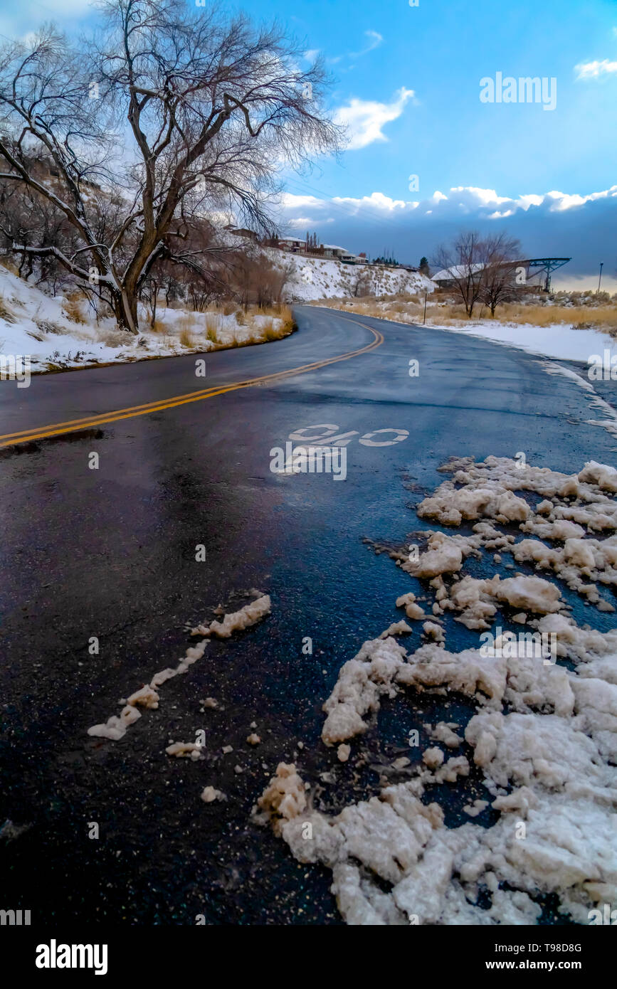 Strada di Montagna contro nuvoloso cielo blu in inverno Foto Stock