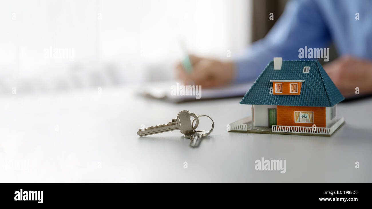 Immobili business concetto - Nuova casa modello in scala e tasti del tabe a agente immobiliare ufficio. spazio copia Foto Stock