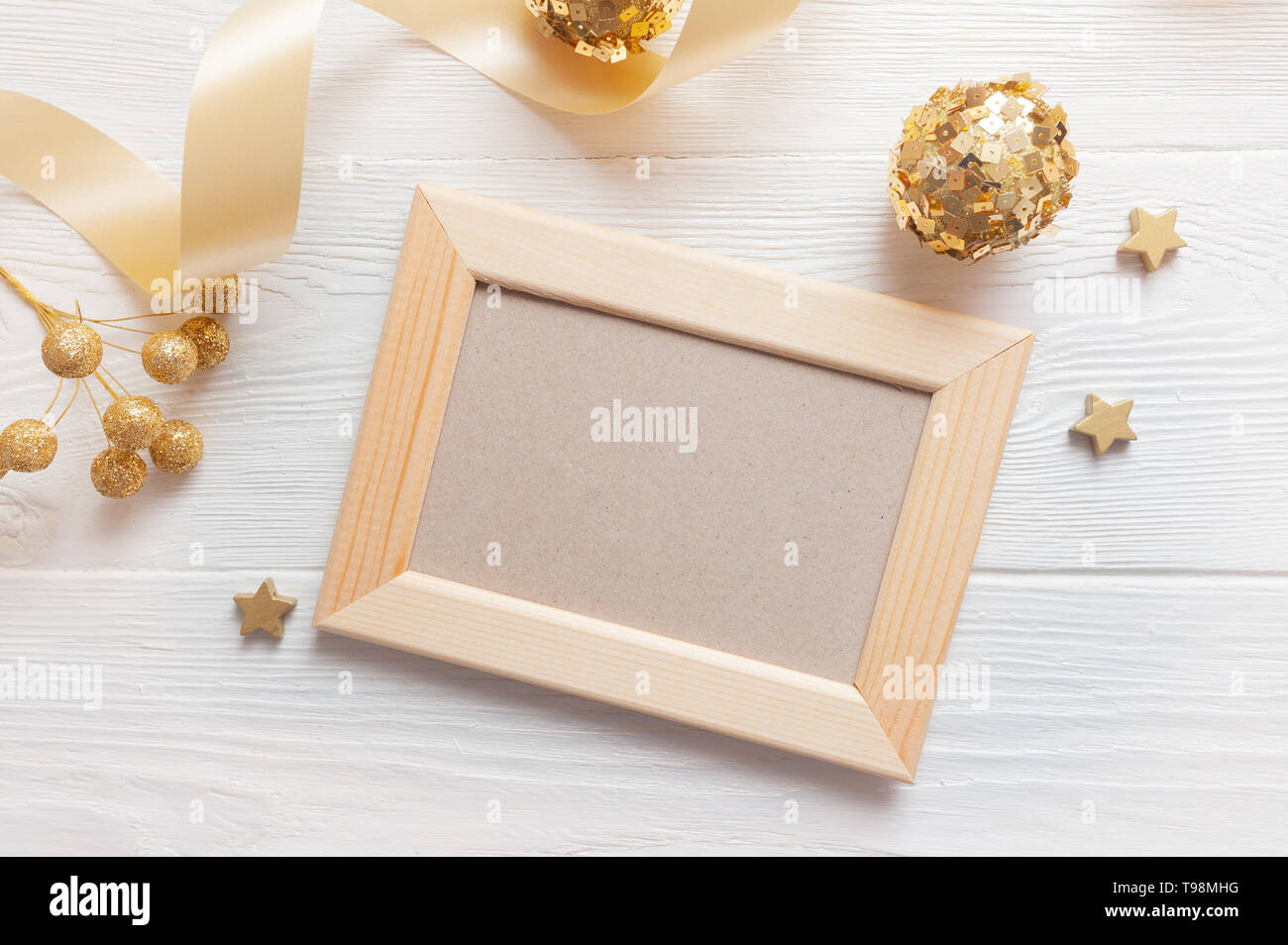 Natale Luce telaio in legno su un sfondo di legno con nastro e golden giocattoli. Piatto, laici top view photo mockup Foto Stock