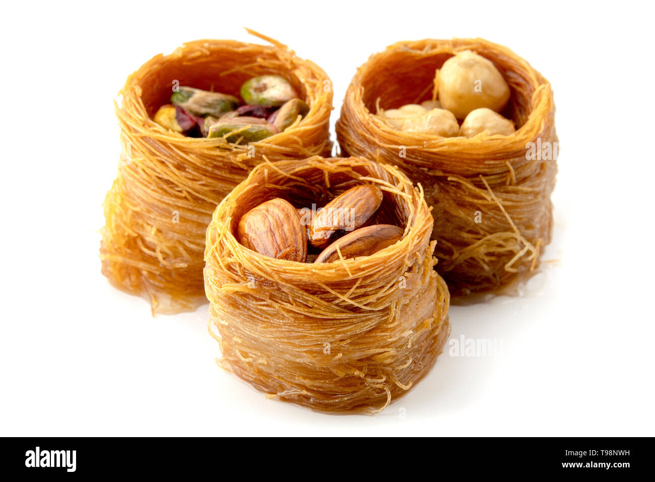 Miscelati Bird Nest baklava con mandorle, noci e pistacchi su sfondo bianco Foto Stock