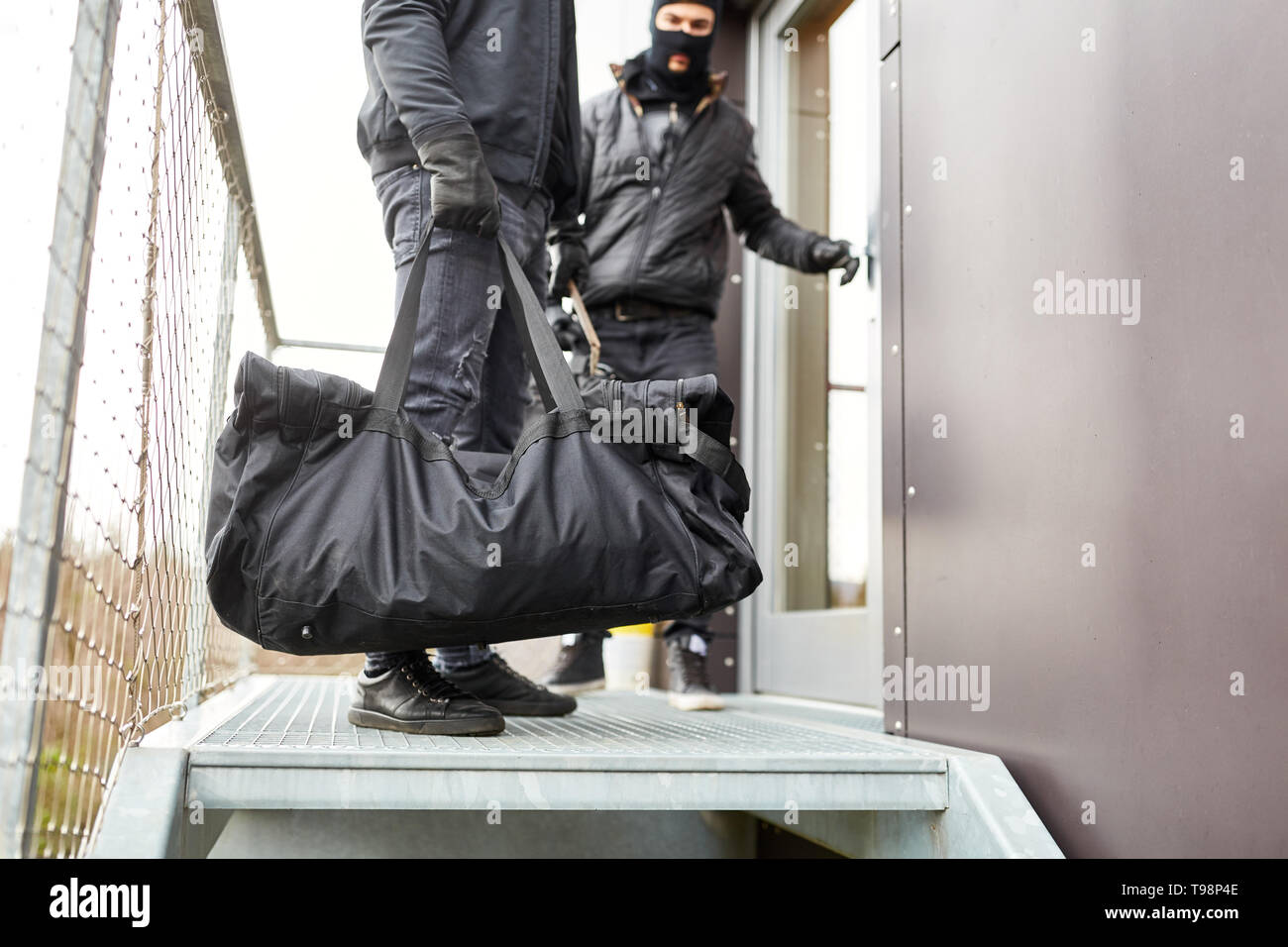 Due ladri in fuga con sacchetto pieno di bottino da office Foto Stock