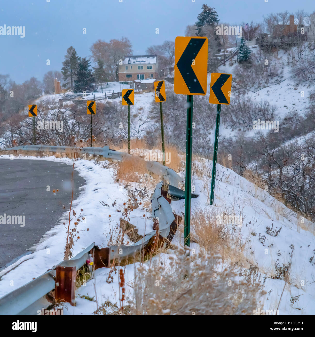 Strada innevata con indicazioni della strada in inverno Foto Stock