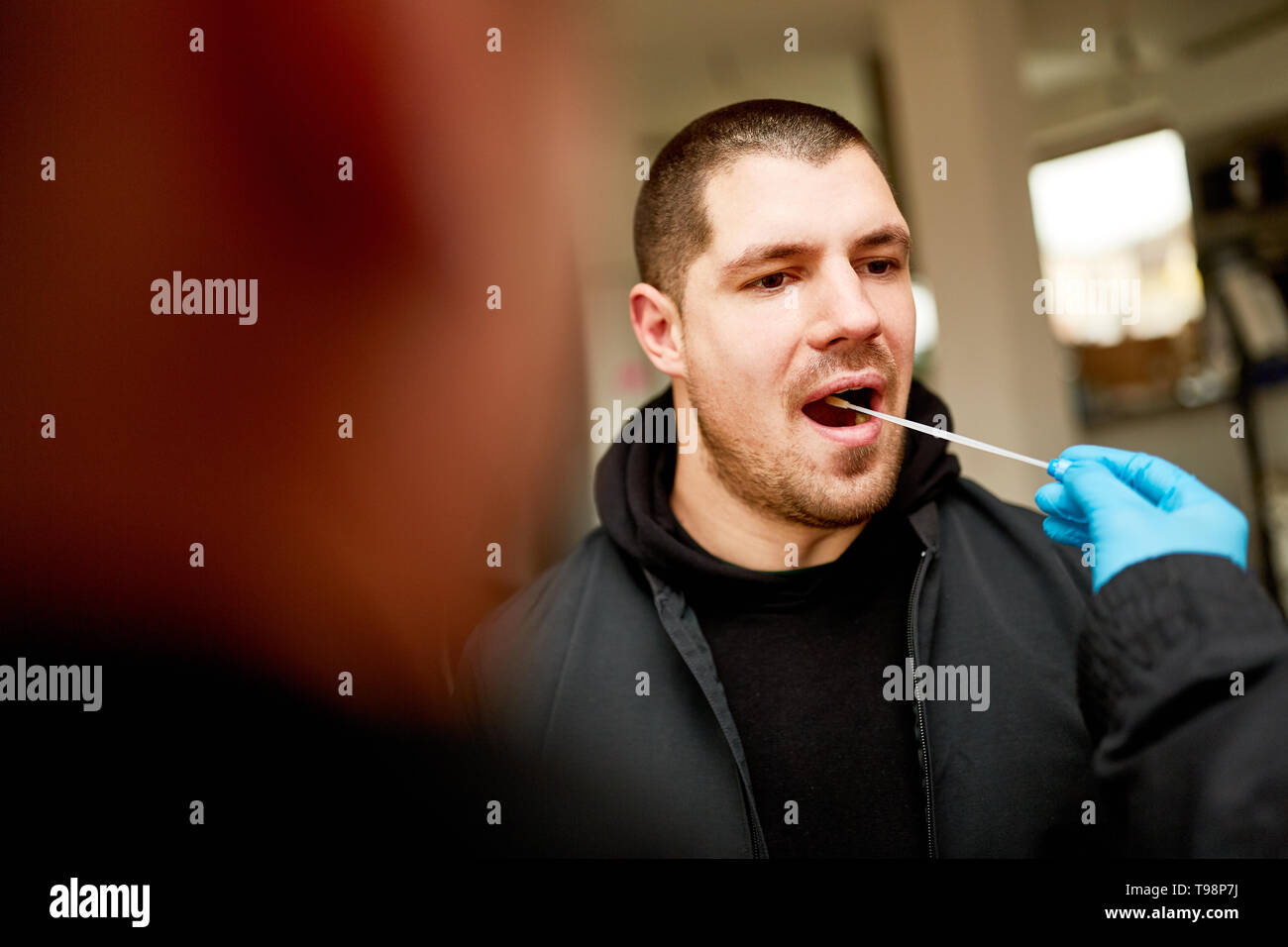 Uomo di dare un campione di saliva per il test del DNA durante le indagini della polizia Foto Stock