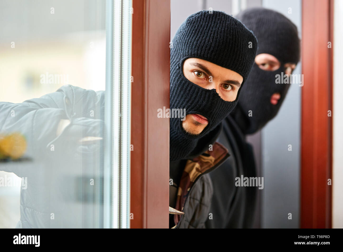 I ladri di apri porta di patio dalla singola famiglia home durante il furto Foto Stock