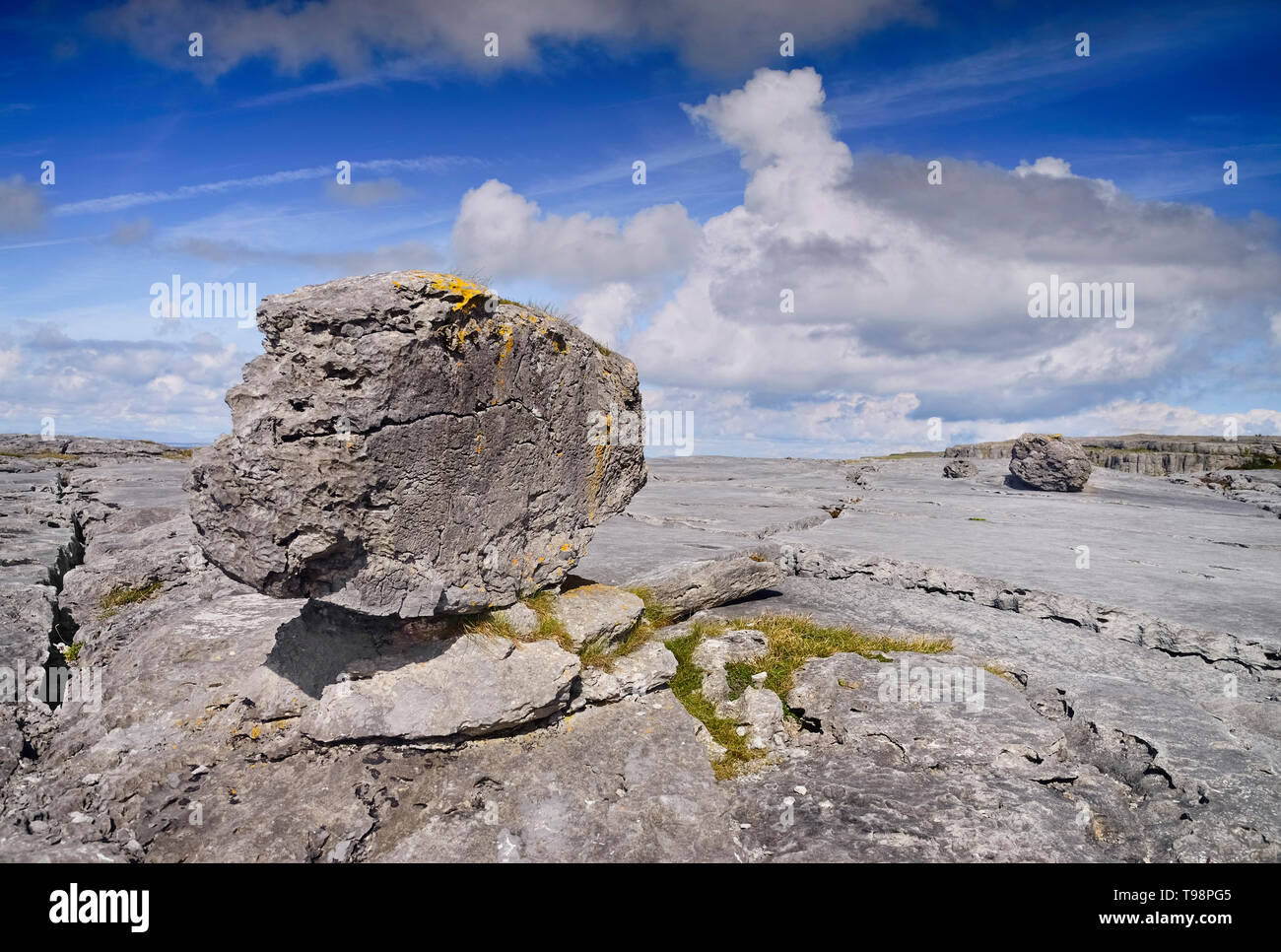 Irlanda, County Clare, Burren, un singolo weathered rock si siede sul tipico paesaggio di pietra calcarea. Foto Stock