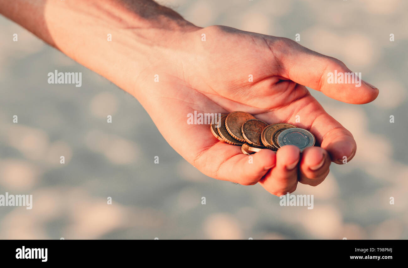 Una manciata di monete su uno sfondo grigio, uomini palms tenere euro, un sacco di soldi, economico le spese, la povertà Foto Stock