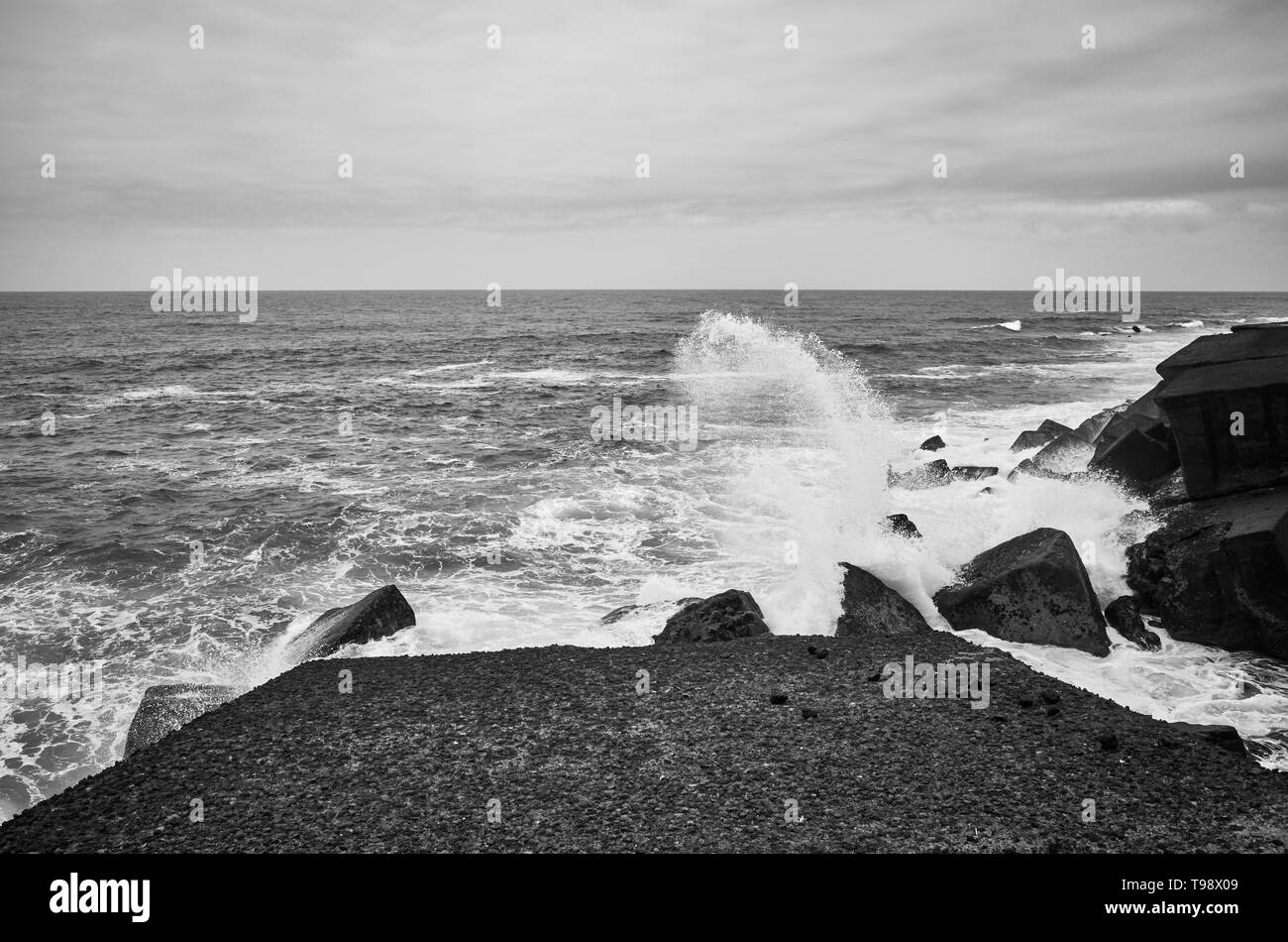 Immagine in bianco e nero di onde che si infrangono sulle rocce, Tenerife, Spagna. Foto Stock